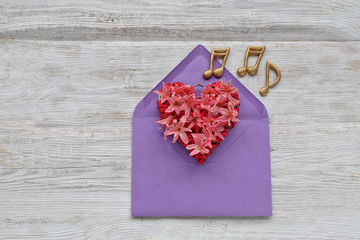 flowers heart in envelope with music note  on wooden background 