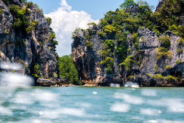Plakat Large cliffs and mountains of islands in Phang Nga archipelago, splash of water from speed boat