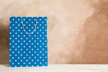 Obraz premium Present bag on white table against brown background, copy space