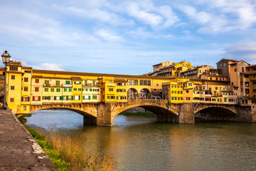 Fototapeta na wymiar Golden hour at the Ponte Vecchio a medieval stone closed-spandrel segmental arch bridge over the Arno River in Florence