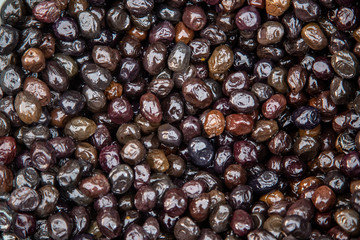 Smoked market fresh black olives as background