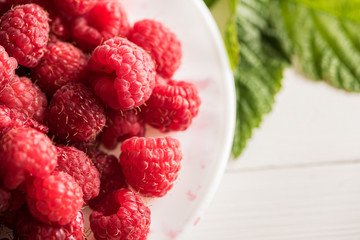 close of fresh organic summer ripe raspsberry  raspberries fileld frame  with green foliage leaves