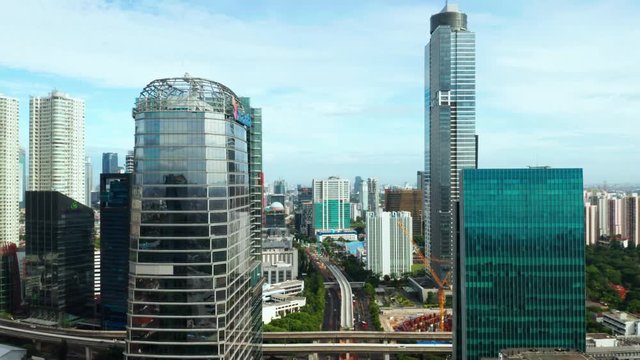 JAKARTA, Indonesia - July 08, 2019: Aerial view of elevated MRT railroad project between modern office buildings in Jakarta city. Shot in 4k resolution from a drone flying backwards