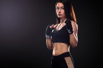 Sportsman, woman boxer fighting in gloves on black background. Boxing and fitness concept.