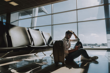 Merry guy is using smart phone at airport