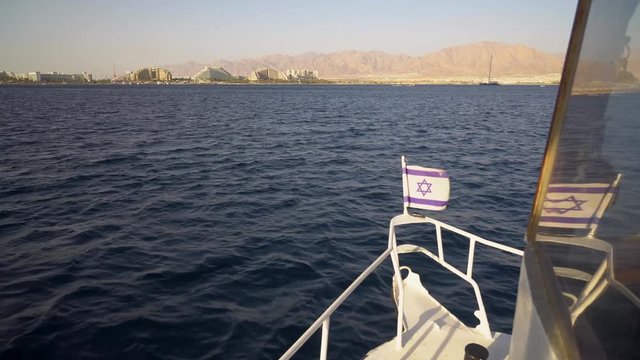 view from the ship sailing to the city of Eilat in Israel. At the stern of the ship a small flag of Israel