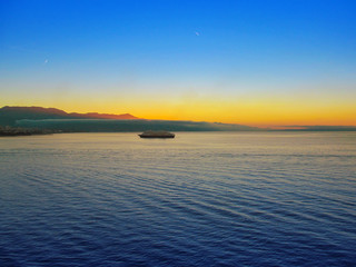 Beautiful morning panorama of Adriatic sea near Split, Croatia. A panoramic view at dawn of a water, sky with a dawning, silhouette of coastline of islands. Nautical landscape of bay in West Europe.