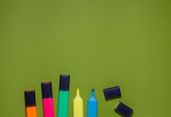 Multi-colored markers on a green background. Back to school concept.