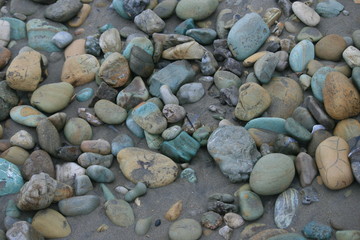Multicolored smooth stones scattered on a beach in Ayampe Ecuador