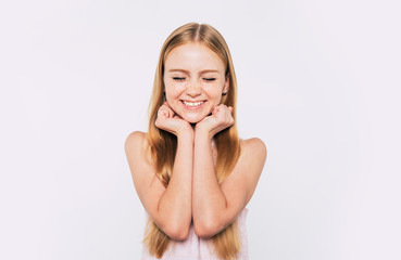 Close up portrait of happy attractive and cute blonde little girl with long hair while she is posing  isolated in studio and smiling