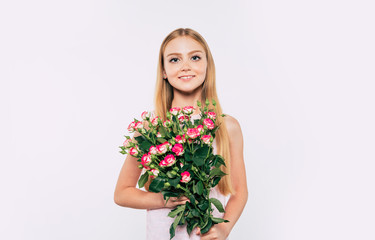 Beautiful, cute, lovely, smiling blonde little girl with happy eyes holds large bouquet of flowers isolated in studio. Birthday, holidays, Valentines day, mothers day concepts.