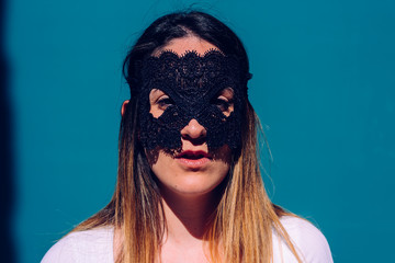 Young woman hides her face behind a mask to escape from stalkers, seeking anonymity and privacy.