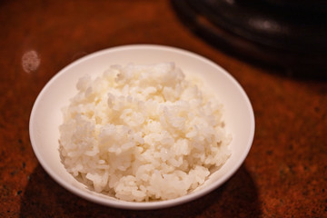Japanese white rice in white bowl on table