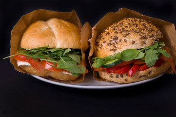 Veggie burger with tomatoes, mozzarella, arugula, paprika and olives