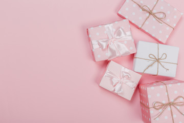 Gift box wrapped in pastel  paper with pink ribbon on pink surface. Top view  and  with copy space.