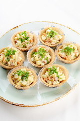 Russian salad canape served green onions for catering. Top view banquet table with cold snacks iIsolated on white background. Party food concept.