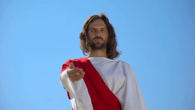 Jesus stretching arm to camera, forgiving sinners, helping hand and charity