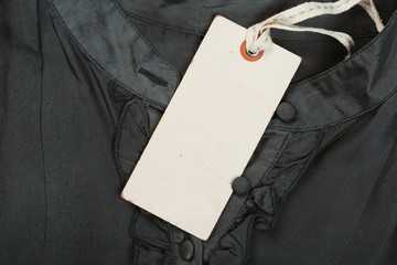 Rectangular Tag on a clothes. fashion, people and shopping concept - close up tag of clothing item
