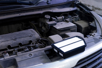 The new air filter is ready to be replaced in the car.