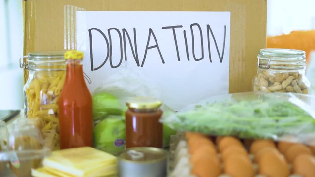 Donation concept. Cardboard box and foods for donation. Shot in 4k resolution