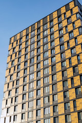 Fototapeta premium The building has a ventilated facade, against a clear blue sky. Urban development and architecture of glass and concrete.