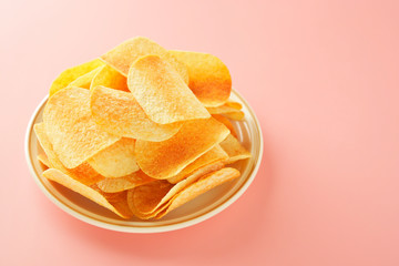Crispy potato chips isolated over pink background. Top view. Copy space.