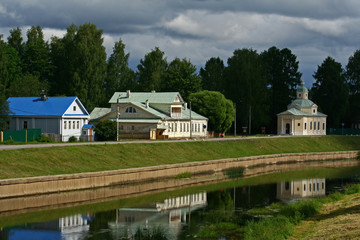Embankment of Tikhvinka river in Tikhvin.  Family house of the Russian composer N. A. Rimsky - Korsakov and Church of All Saints 