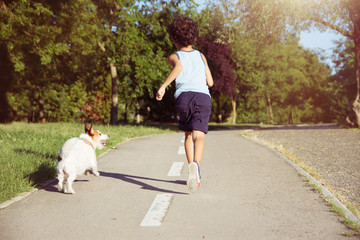 Fototapeta premium Dog and child running at the park. off leash. Friendship concept.