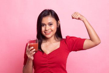 Strong healthy Asian woman with tomato juice.