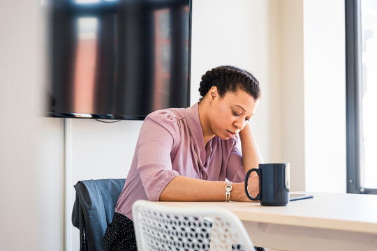 Thoughtful businesswoman looking at tablet