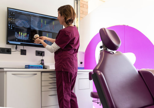 Dentist checking a dental mold in dental clinic.