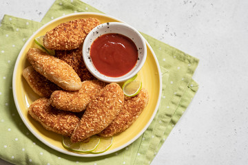 Chicken strips nuggets with tomato sauce on a plate