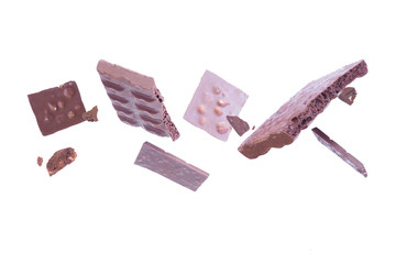 Levitating pieces of broken chocolate on a white background...