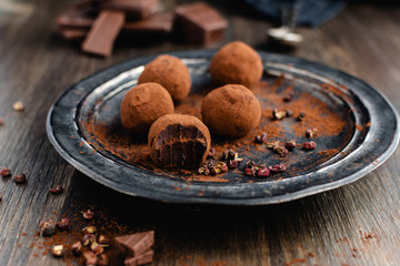 dark chocolate candy truffles with sichuan pepper on dark background