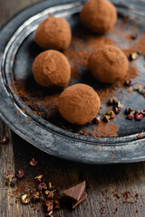 dark chocolate candy truffles with sichuan pepper on dark background