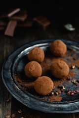 dark chocolate candy truffles with sichuan pepper on dark background