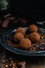 dark chocolate candy truffles with sichuan pepper on dark background