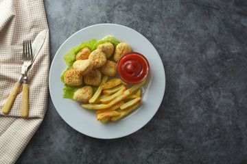 Chicken nuggets with french fried potatoes and ketchup, top view. Fast food.