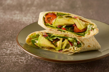 Tortilla wraps with avocado, cherry tomato. Healthy, vegan food. Take away snack.