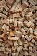 Sliced in cubes dark bread pieces crackers top view close up background. Bread texture. Bread backdrop