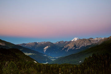 Naklejka premium Scenic view of beautiful Swiss Alps mountains. sunset with pink blue tones