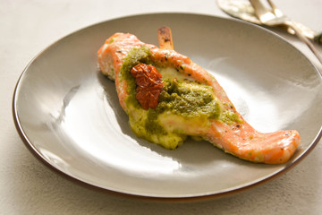 Baked salmon filled with with cherry and pesto, isolated in stylish plate. Healthy food.