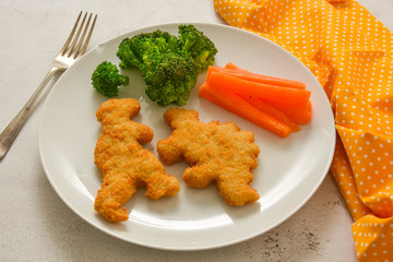 Kids food. nuggets with vegetables. Dinosaur shaped chicken, fish or turkey nuggets, ready to eat.