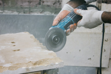 Worker cutting stone block by cutter machine.
