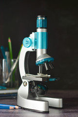 Education, science and children concept. Microscope isolated on black background. Studying biology at school laboratory.