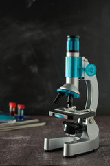 Education, science and children concept. Microscope isolated on black background. Studying biology at school laboratory.