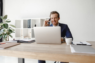 Contented entrepreneur with smartphone in his hand