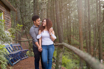latin couple holding hands seeing each other in the middle of the forest - couple in love