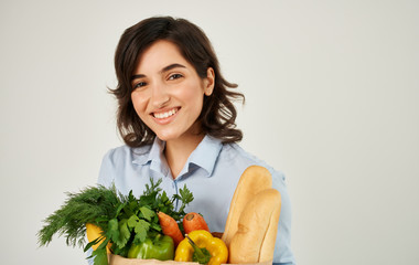 young woman holding shopping bag full of groceries