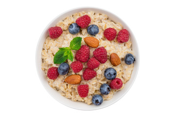 Oatmeal with raspberries, almonds and blueberries and mint top view isolated on white